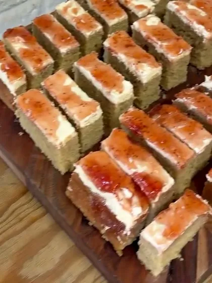 Board of vegan sponge cake slices with cream and jam