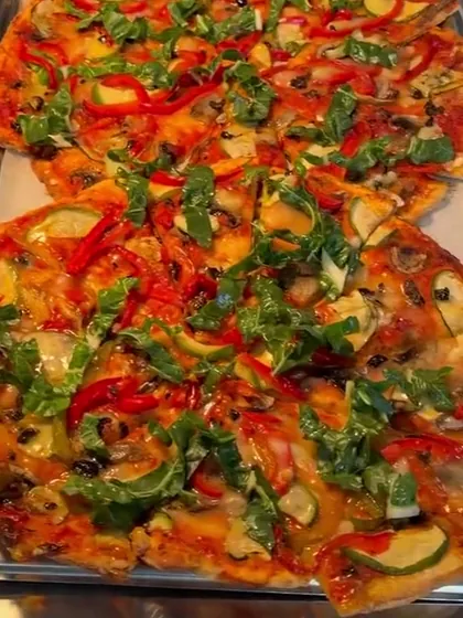 Vegan pizza topped with roast capsicum, zucchini and rocket