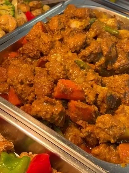 Tray of rendang, a dark spiced curry with plant protein, carrot and sweet potato