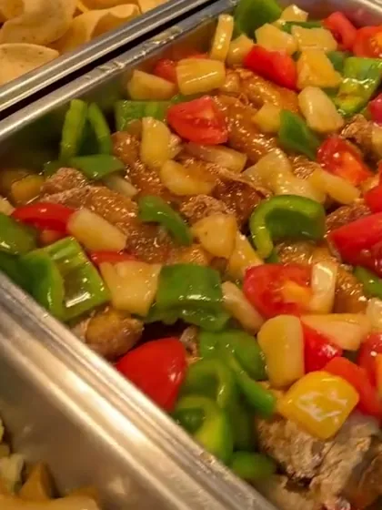 Tray of sweet and sour with red and green capsicum, tomato and pineapple